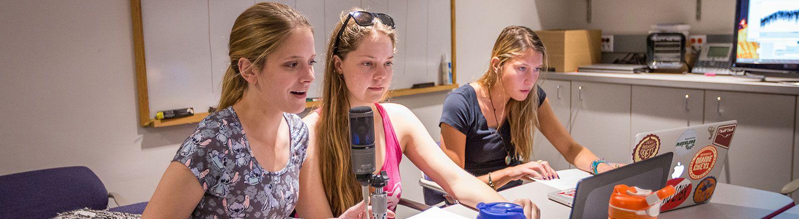 Group of students speaking into microphone in audiology clinic